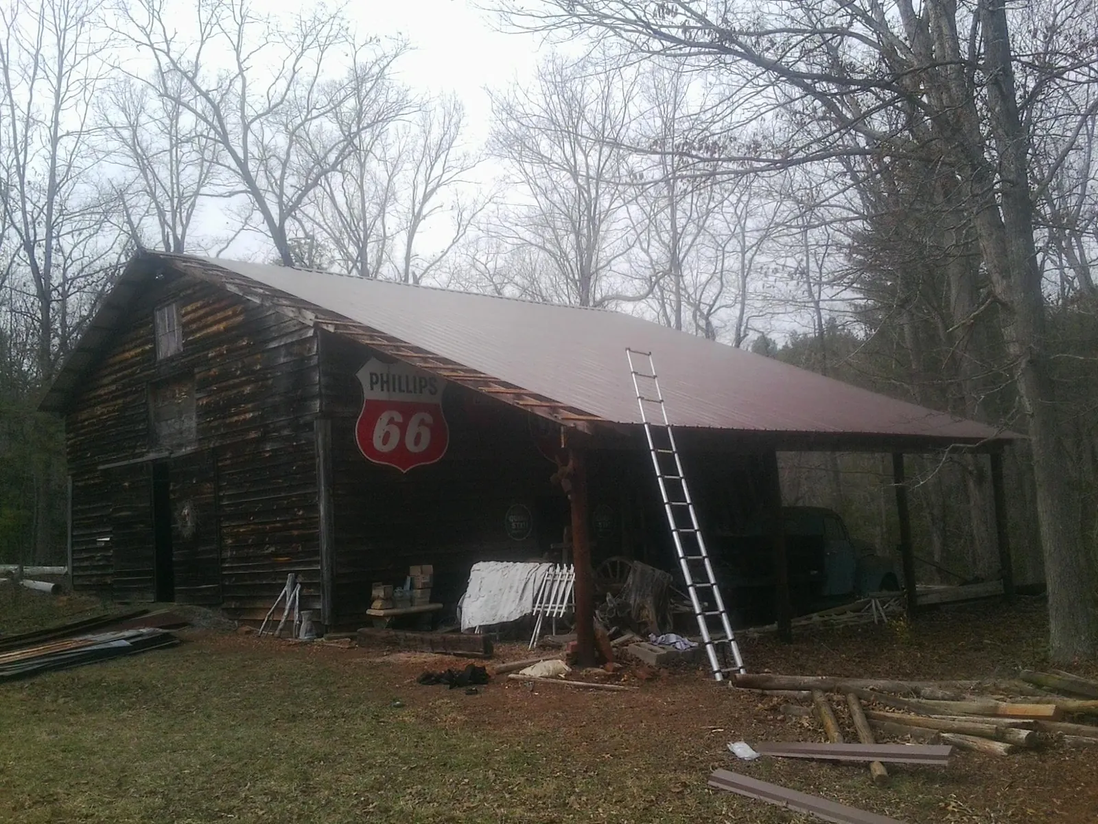 New metal roof on an open sided timber barn with a vintage sign in Rush Center
