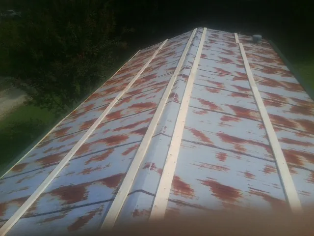 Rusted metal roof panels with new wood purlins before replacement — Storm Damage Roof Repair in Rush Center by Roofing Brothers
