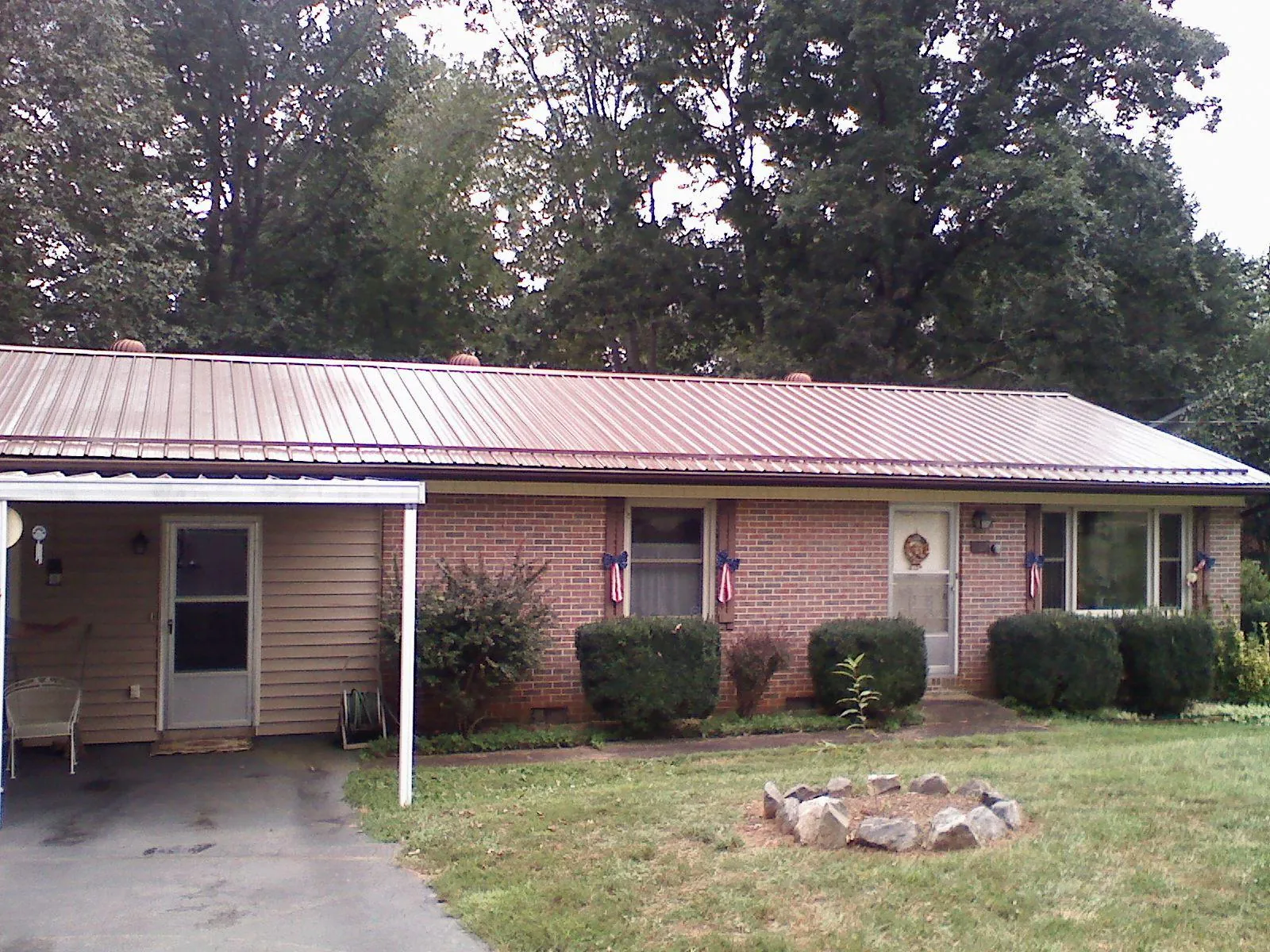 Bronze metal roof and carport on a brick ranch home — Roof Repair work by our crew in Rush Center